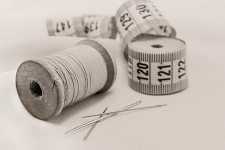 Retro needle and thread lie on the fabric. Tools for a tailor or seamstress. black and white photographyの写真素材