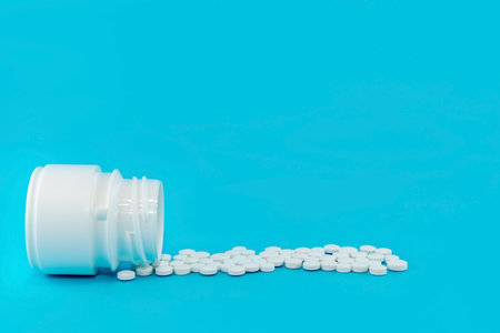 Medical pills with a bottle on a blue background. Medical drugs with free space for an inscription....