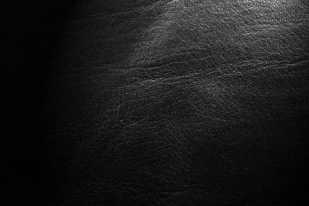 Black leather texture. Abstract background of dark leather with small roughness and scuffsの写真素材