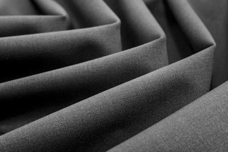 Dense luxurious black fabric with folds and waves. Material for tailoringの写真素材