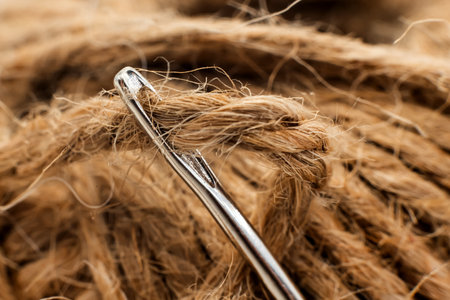 The eye of a needle for sewing with thread close-up. Needle with twineの写真素材