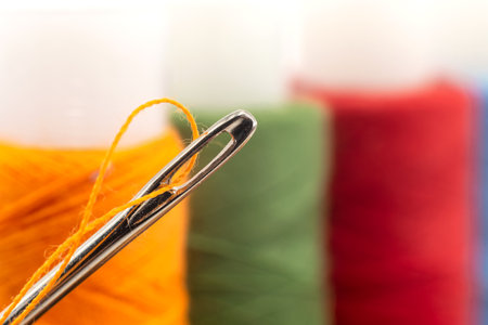 Multi-colored spools of thread close-up. Needle with thread. Seamstress or tailor's toolsの写真素材