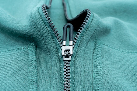 Close-up of the zipper on the green clothing. Zipper with lock. Fabric with zipperの写真素材