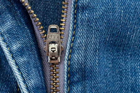 Closeup of zipper in blue jeans. Zipper with lock. A piece of denim