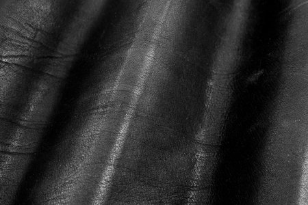 Black leather texture. Abstract background of dark leather with small roughness and scuffs
