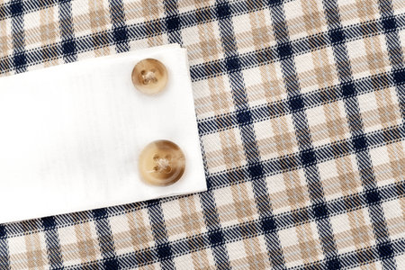 Buttons on a plain shirt. Spare buttons sewn to the shirt