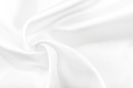 A twisted piece of white fabric. White material or texture with waves and folds. Wrinkled white fabricの写真素材