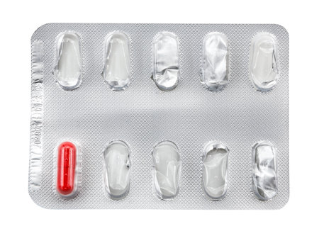 Medical capsule in a package on a white background. One red tablet in an empty package. Healthの写真素材