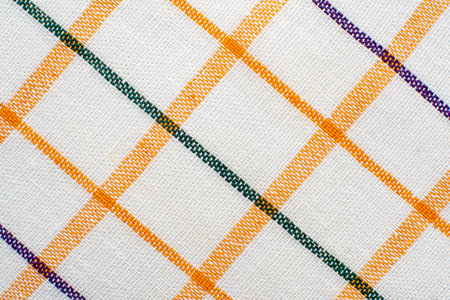 The texture of linen fabric in a large cell of orange and white. Scottish tailoring material