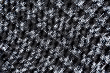 Texture of black and white fabric in a cage. Checkered material. Textile with intersecting white and black linesの写真素材