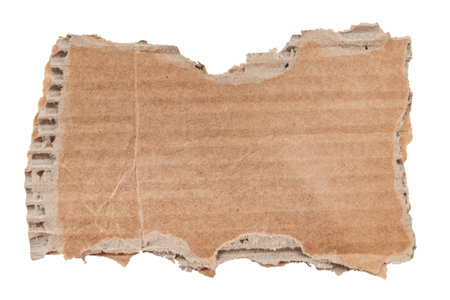 A piece of textured packaging cardboard. Piece of torn cardboard with copy space. Brown wrapping vintage paper, isolated top view. Kraft paper isolated on white backgroundの写真素材