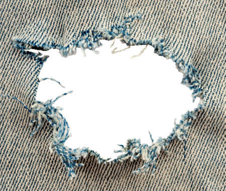 Hole in denim on a white background. Ripped jeansの写真素材