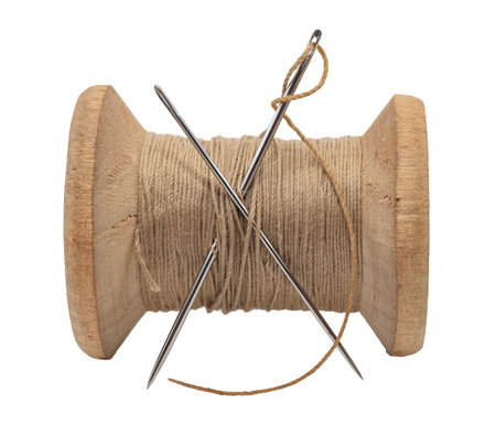 Old wooden spool of thread and needle on a white background. Sewing accessoriesの写真素材