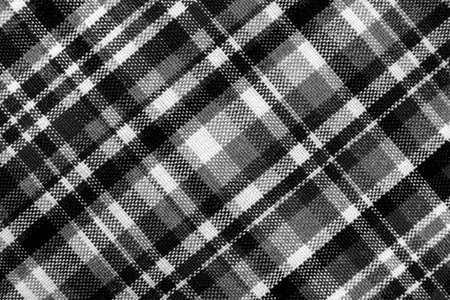 Texture of check fabric with white and black checks. Checkered black and white fabric background. Scottish tailoring material.の写真素材