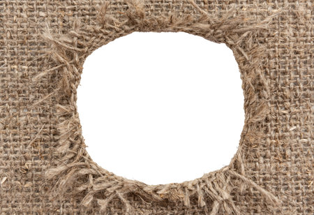 Hole in burlap. Torn piece of burlap fabric with a hole in the middle textureの写真素材