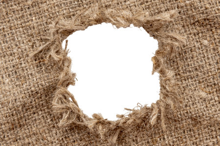 Hole in burlap. Torn piece of burlap fabric with a hole in the middle textureの写真素材