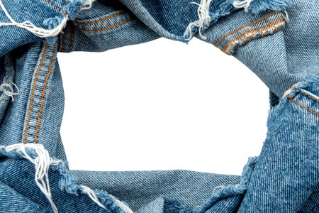Hole in denim on a white background. Ripped jeans