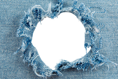 Hole in denim on a white background. Ripped jeansの写真素材