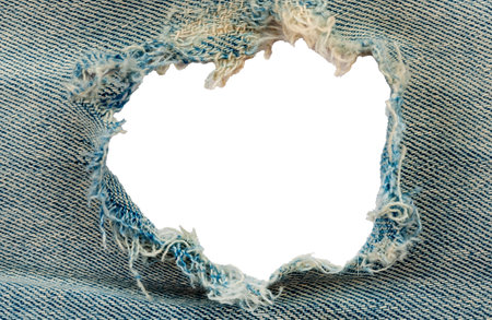 Hole in denim on a white background. Ripped jeansの写真素材