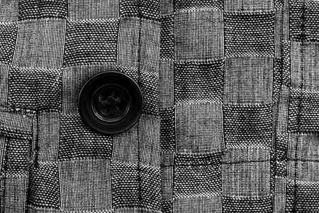 Close-up of a button on a black suit. Button on a suit