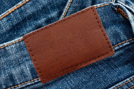Empty worn leather patch on blue jeans. Empty space for writing. Blank leather jeans labelの写真素材