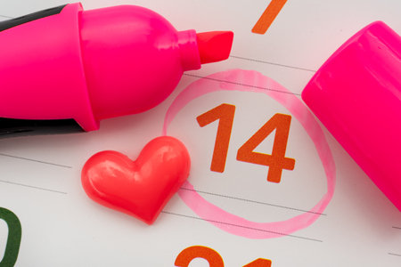 Red heart lies on a calendar. Valentine's Day. Date circled with markerの写真素材
