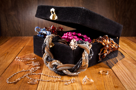 Kiev, Ukraine - February 26, 2018: Black, suede box with jewels on a wooden table.の写真素材