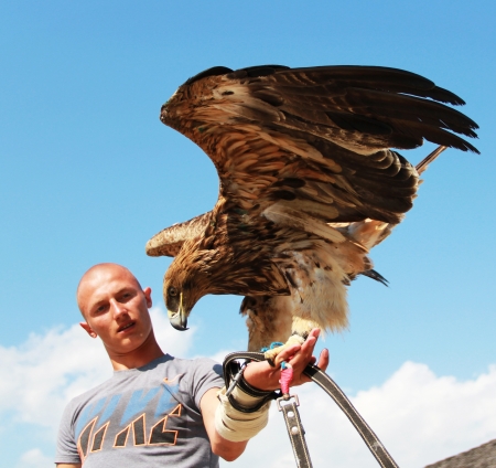 KAMYANETS-PODILSKY, UKRAINE- JUNE 2: Undefined young man with hunting eagle during Forpost (The Outpost) Festival of Medieval Culture on June 2, 2012, Kamyanets-Podilsky, Ukraineのeditorial素材
