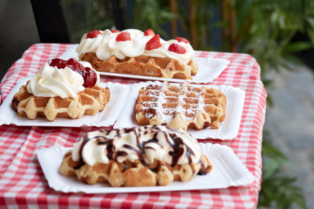 Popular national dish Belgian waffles with strawberries, cherries, chocolate and powder in the tourist town of Bruges.の写真素材