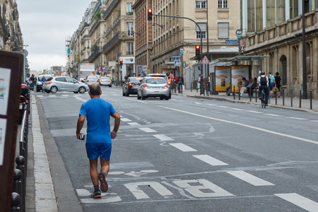 A man runs around the streets of Paris in the morning.の写真素材