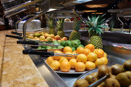 Buffet on the cruise ship. Fruit: kiwi, oranges, apples and pineapples.の写真素材