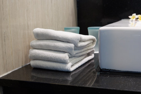 Stack of white towels in a hotel bathroom closeup.の写真素材