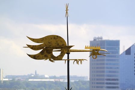 Old golden weathercock on roof in Tallinnの写真素材