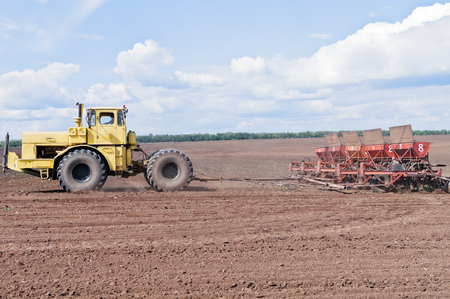 Tractor with seeder in the fieldの写真素材