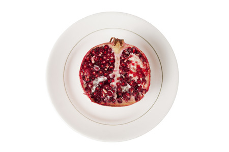 Cut pomegranate on a plate, top viewの写真素材