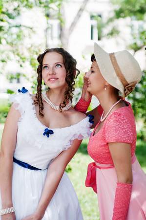 Girls in vintage dresses, tell each other secretsのeditorial素材