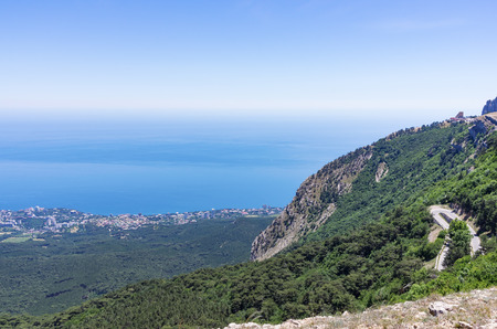 Mountain slope with a road near the sea coast. Russia, Republic of Crimea. 06.13.2018. The slope of Mount Ai-Petri with a highway and views of the Black Seaのeditorial素材