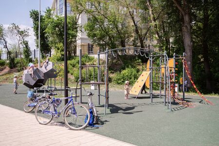 Orenburg, Russia - June, 1, 2019: Embankment of the Urals. Summer. Bicycles parked near the playground, with children playingのeditorial素材