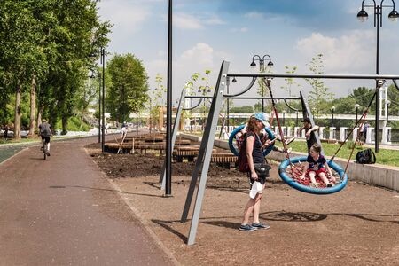 Orenburg, Russia - June, 1, 2019: Young mother with children at the playground. Section of the embankment of the Ural Riverのeditorial素材