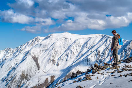 Severo-Chuy ridge, Uchitel pass, Altai Republic, Russia - September, 16, 2019: A tourist looks down, standing on a mountain peakのeditorial素材
