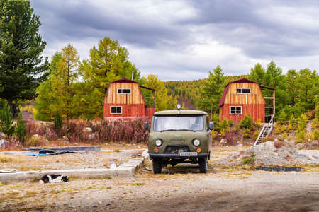 Ulagansky District, Altai Republic, Russia - September, 18, 2019: Sleeping dog and four-wheel drive car in the courtyard of the camp site near Uzunkel Lakeのeditorial素材