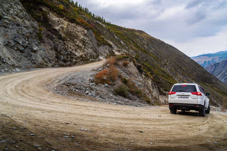 Ulagansky District, Altai Republic, Russia - September, 18, 2019: A car going down a mountain road from the Katu-Yaryk pass to the valley of the Chulyshman Riverのeditorial素材