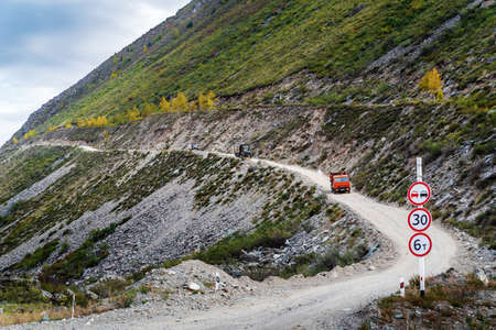 Ulagansky District, Altai Republic, Russia - September, 18, 2019: Trucks descending along a mountain road from the Katu-Yaryk pass to the Chulyshman valleyのeditorial素材