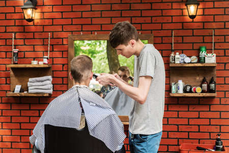 Orenburg, Russia - July, 20, 2019: Men's haircut at the hairdresser in the open air. FORMA MARKET - a city festival for the promotion of handmade designers, artisans and their projects with the aim of engaging in the business environmentのeditorial素材
