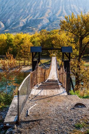 Suspension bridge over a mountain river in a gorge. Russia, Altai Republic, Ulagansky District, Chulyshman Riverの写真素材