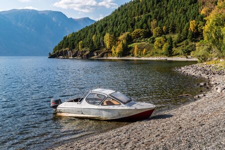 Motor boat near the shore of a mountain lake. Fall. Russia, Altai Republic, Lake Teletskoyeの写真素材
