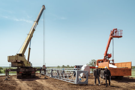 Orenburg, Russia - May, 26, 2020: Installation of a wind turbine. Workers and engineers, truck crane and aerial platform at construction siteのeditorial素材