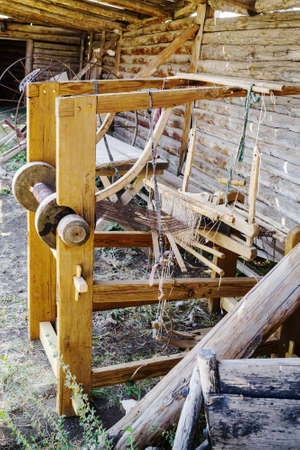 An old wooden hand loom in the courtyard of an old village house. Cossack estate in the village of Arkaim, Russiaの写真素材