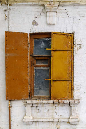 A window with iron shutters on the facade of an old building. The picture was taken in Russia, in the city of Orenburgの写真素材