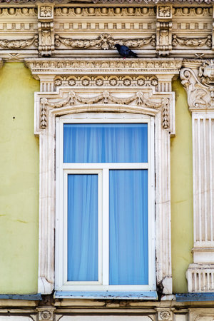 A plastic window in the wall of an old building with stucco molding, a fragment of the facade. The picture was taken in Russia, in the city of Orenburgの写真素材